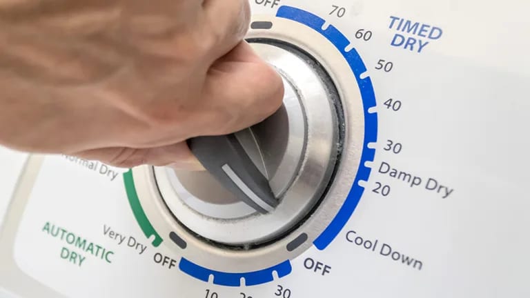 dryer timer turned by a hand