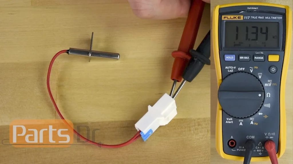 a picture of thermistor getting checked with multimeter